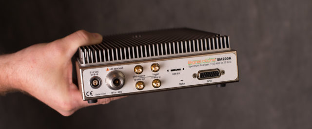 The Signal Hound SM200A spectrum analyzer, held in hand